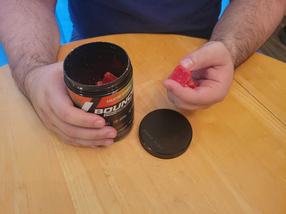 A man holding Bounce Nutrition Creatine Gummies next to the container