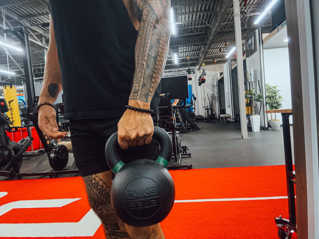 Product tester Stephen Sheehan holding a 24-kg Giant Lifting V3 Kettlebell by the handle in his left hand
