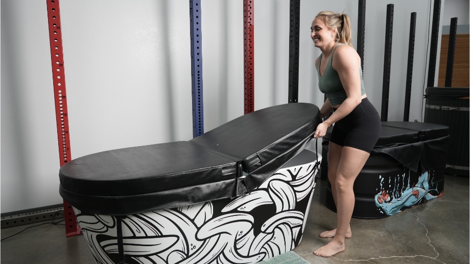 A person is shown taking the lid off of a Polar Monkeys cold plunge tub.
