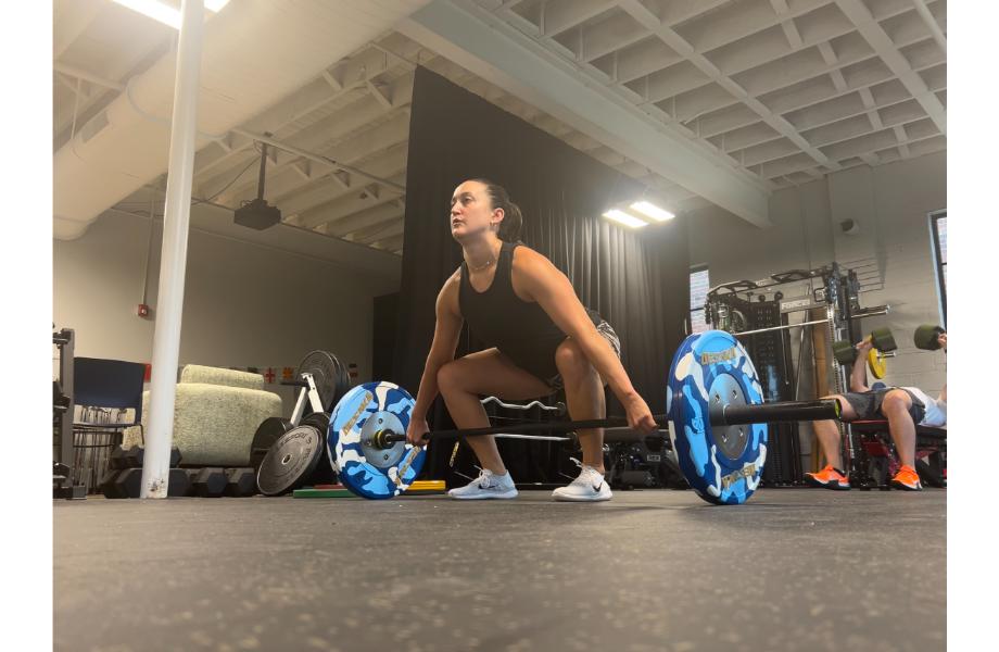 Woman performing snatches with the Synergee Games Barbell